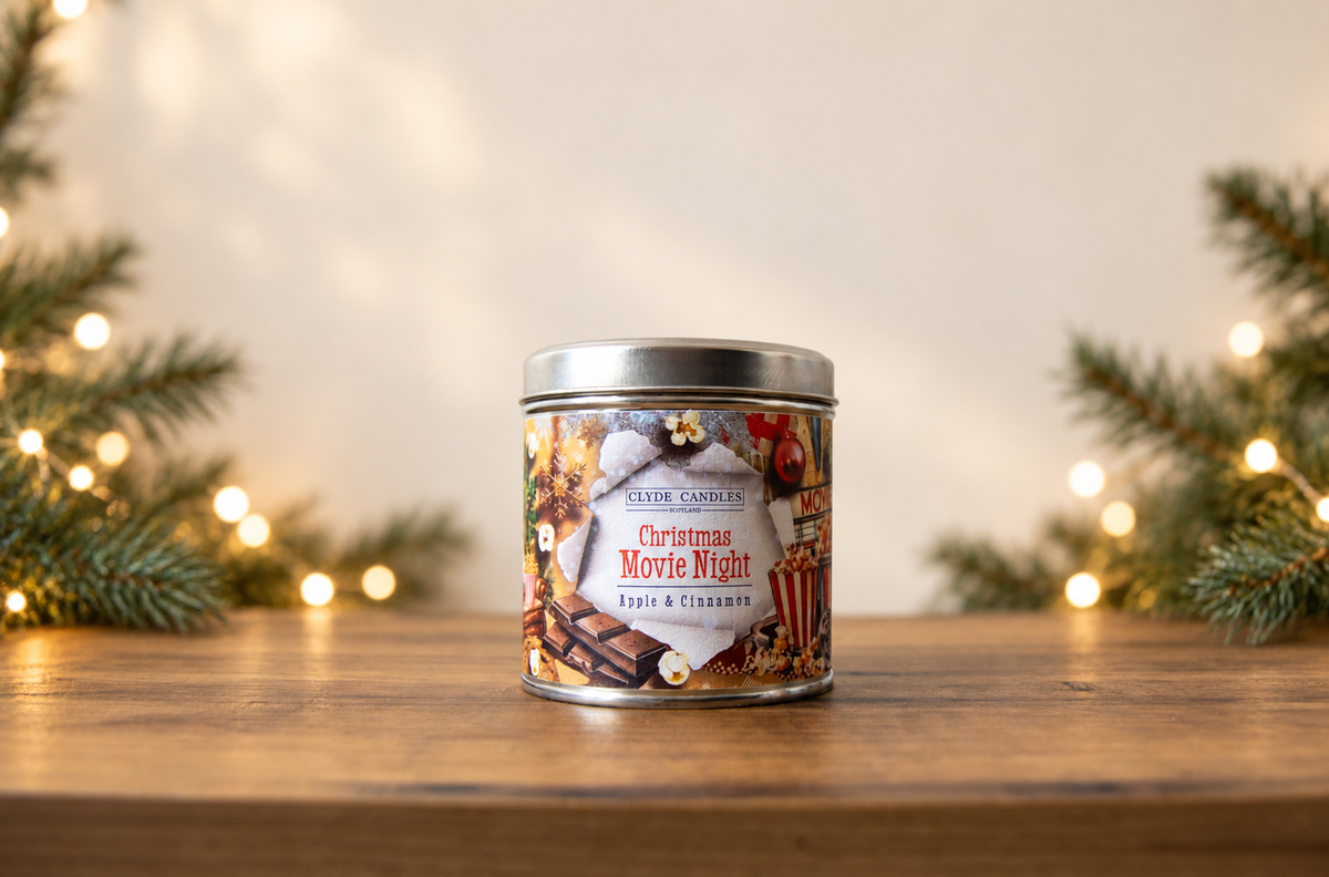Clyde Candles Christmas Movie Night Apple & Cinnamon candle in a festive illustrated tin with a silver lid