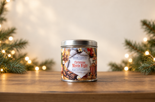 Clyde Candles Christmas Movie Night Apple & Cinnamon candle in a festive illustrated tin with a silver lid