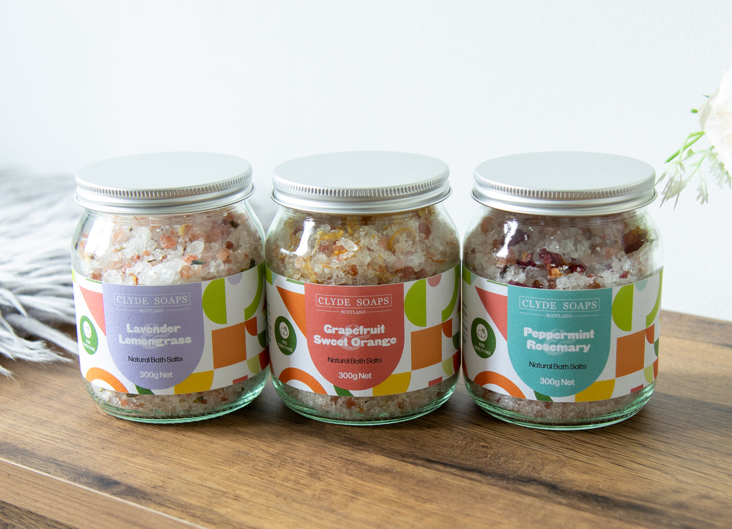 Relaxing bath with Clyde Candles Lavender & Lemongrass Bath Salts beside tub
