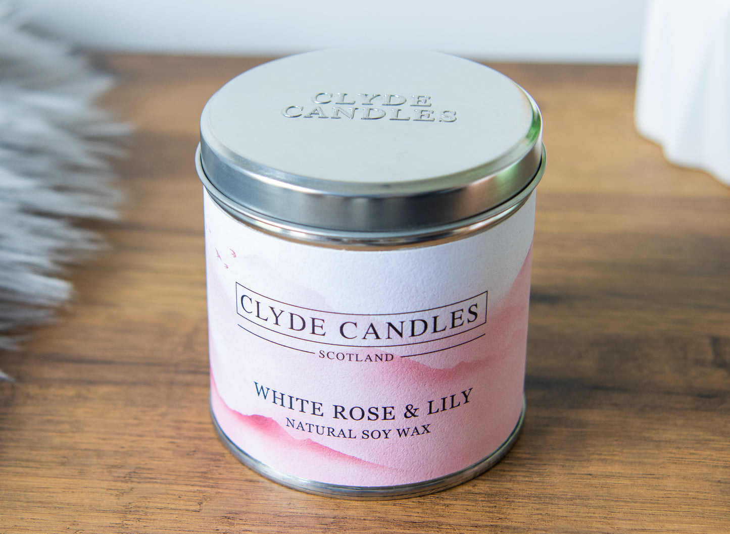 Clyde Candles White Rose & Lily candle on a wooden surface