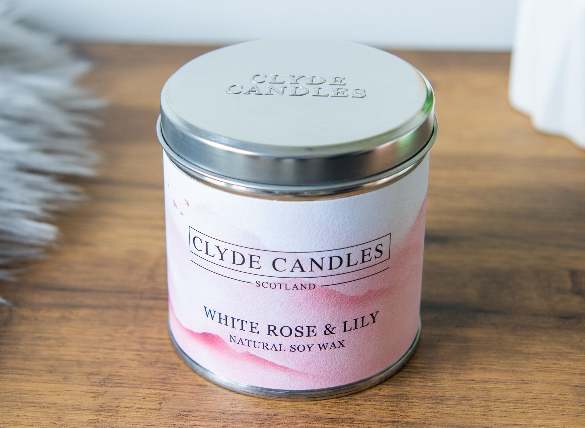 Clyde Candles White Rose & Lily candle on a wooden surface